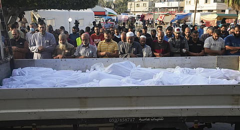 Palestinians pray by the bodies of people killed in the Israeli bombardment in Deir Al-Balah, Gaza Strip, Monday, Oct. 23, 2023.(Photo | AP)