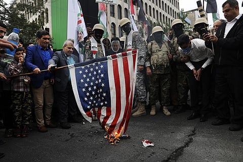 Iranians along with the Basij paramilitary force burn a US flag during a pro-Palestinian rally in Tehran, Iran, Friday, Oct. 13, 2023. (Photo | AP)