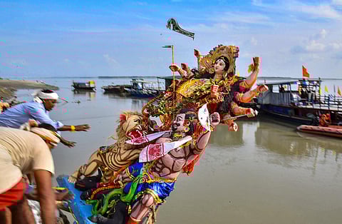 Devotees immerse an idol of Goddess Durga at the bank of Brahmaputra river after the end of the Durga Puja festival, in Tezpur, Assam. (PTI0