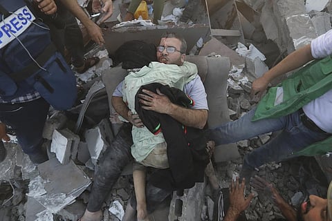 An injured Palestinian man hugs an injured relative after being rescued following Israeli airstrikes on Gaza City, Wednesday, Oct. 25, 2023. (Photo | AP)