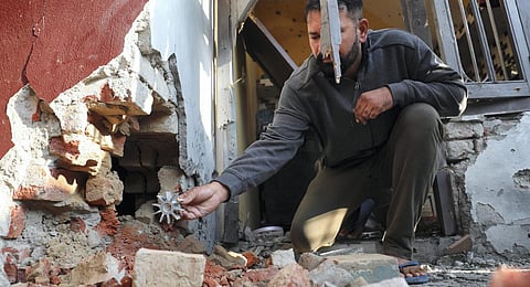 A villager sits near a damaged house following unprovoked firing by the Pakistan Rangers along the international border, at a village near Jammu. (Photo | PTI)
