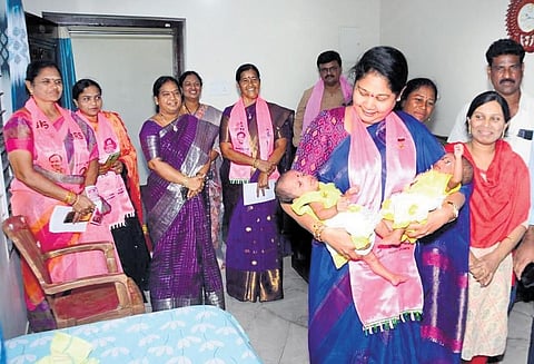Vasantha Lakshmi, wife of Minister Puvvada Ajay Kumar, holds the babies of a voter during her campaign in  Khammam on Saturday.