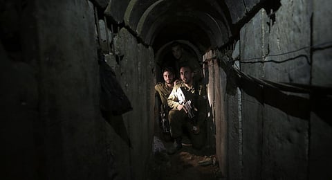 Israeli soldiers walk through a tunnel discovered near the Israel-Gaza border. (Photo | AP)