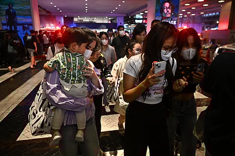 People leave Siam Paragon shopping centre in Bangkok on October 3, 2023, following a shooting incident in the mall. (Photo | AFP)