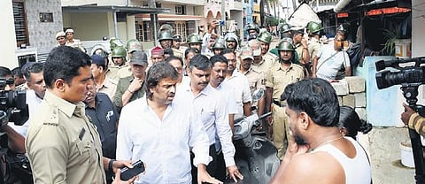 Shivamogga district minister Madhu Bangarappa interacts with residents of Shantinagar in Shivamogga on Tuesday. (Photo | Shimoga Nandan)