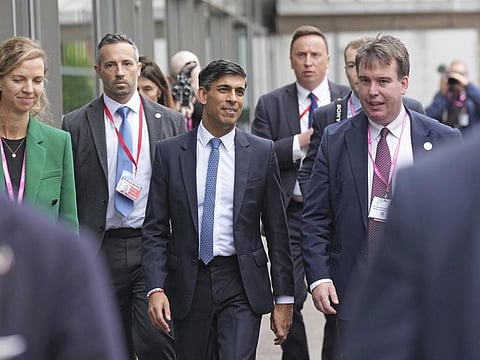 Britain's Prime Minister Rishi Sunak, centre, walks, during the Conservative Party annual conference at the Manchester Central convention complex. (Photo | AP)