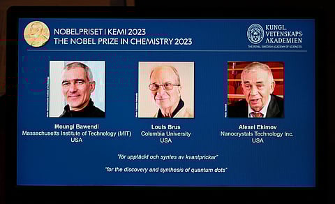 A tablet shows this year's laureates US Chemist Moungi Bawendi, US Chemist Louis Brus and Russian physicist Alexei Ekimov of the 2023 Nobel Prize in chemistry. (AFP)
