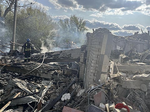 Firefighters work to extinguish a fire after the deadly Russian rocket attack that killed more than 40 people in the village of Hroza near Kharkiv, Ukraine. (Photo | AP)