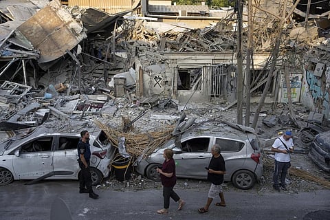 Israelis inspect the rubble of a building a day after it was hit by a rocket fired from the Gaza Strip, in Tel Aviv, Israel. (Photo | AP)