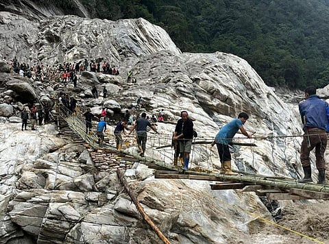 A temporary bamboo bridge being constructed at Chungthang connecting it to Pegong, days after flash floods, in Mangan district, Sikkim, Sunday, Oct. 8, 2023. (Photo | PTI)