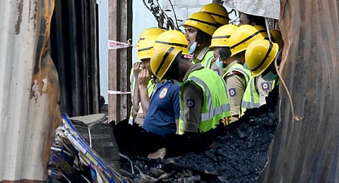 Fire and Police personnel at the spot on Sunday, where cracker shops gutted in fire at Attibele in which 14 people died and few more injured, on Saturday. (Express)
