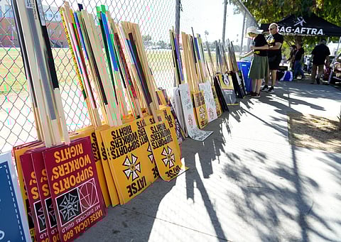Striking SAG-AFTRA members pick out signs for a picket line outside Netflix studios, Wednesday, Nov. 8, 2023, in Los Angeles. (Photo | AP)