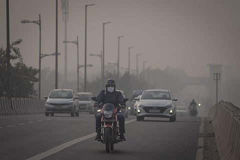 A motorcyclist drives wearing pollution mask amid smog in New Delhi, India, Nov. 7, 2023. (AP)