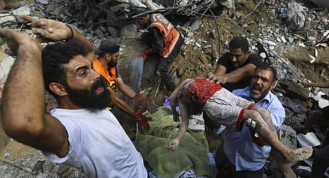 Palestinians carry the body of a dead child who was found under the rubble of a destroyed house after Israeli airstrikes on Gaza City. (Photo | AP)