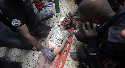 Palestinians rescue a wounded girl from under the rubble of a destroyed building following an Israeli airstrike in Khan Younis refugee camp, southern Gaza Strip. (Photo |AP)