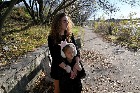 Anna Lyashko, 28, and her daughter Diana, 8, walk in a park near the Dnipro river in Kyiv on November 3, 2023, amid the Russian invasion of Ukraine. (Photo | AFP)