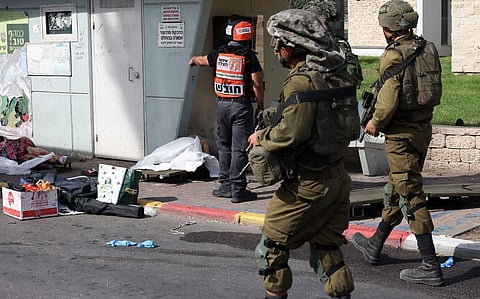 Israeli soldiers walk near the bodies of Israeli civilians killed by terrorists from Gaza in the southern city of Sderot on October 7, 2023. (Photo | AFP)