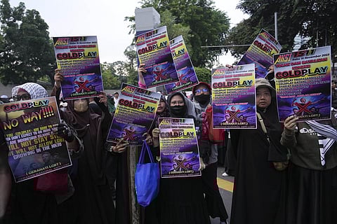 Muslim women hold posters during a rally against British band Coldplay ahead of its concert in Jakarta, Indonesia, Wednesday, Nov. 15, 2023. (AP)