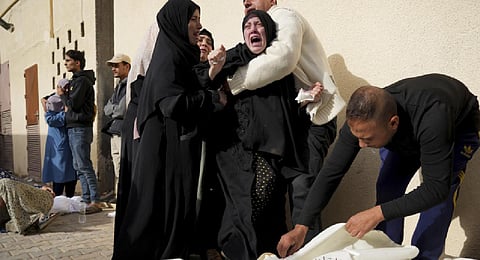 Palestinians mourn relatives killed in the Israeli bombardment of the Gaza Strip in front of the morgue in Deir al Balah, Sunday, Nov. 19, 2023. (AP Photo)