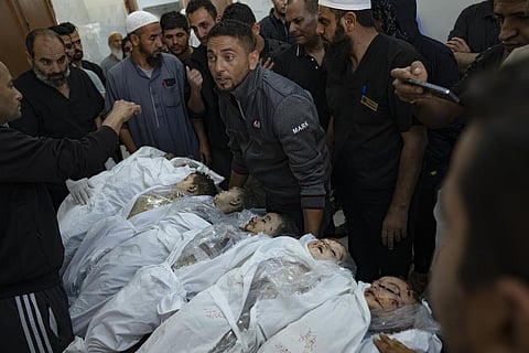 FILE - Palestinians stand around the bodies of children killed in Israeli bombardment of the Gaza Strip in a morgue in Khan Younis, Thursday, Oct. 19, 2023. (Photo | AP)
