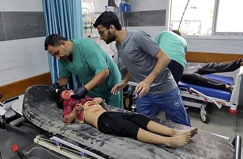 A Palestinian wounded girl receives treatment at Kama Adwan hospital following Israeli bombardment on a UN school used as shelter, in Jabaliya. (Photo | AP)