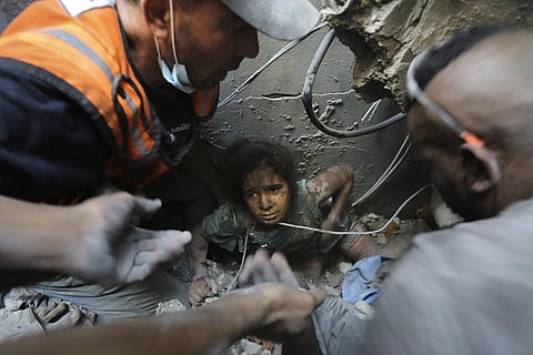 Palestinians try to pull a girl out of the rubble of a building that was destroyed by Israeli airstrikes in Jabalia refugee camp, northern Gaza Strip, Wednesday, Nov. 1, 2023. (Photo | AP)