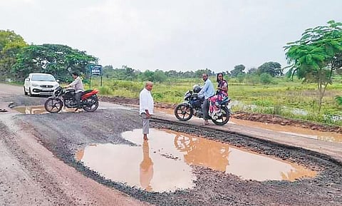 A file photograph of commuters passing through a damaged road connecting Chilvar in Andole constituency to Bidar in Karnataka
