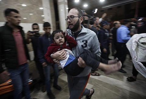 A wounded Palestinian child is carried into the Nasser Hospital following an Israeli bombardment on Khan Younis refugee camp, Tuesday, Nov 21, 2023. (Photo | AP)