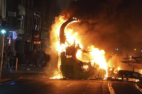 A bus on fire on O'Connell Street after violent scenes unfolded in Dublin city center. (Photo | AP)