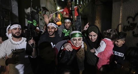 Aseel al-Titi, wearing a Hamas headband, a former Palestinian prisoner who was released by the Israeli authorities, is greeted by friends and family members in Balata.(Photo | AP)