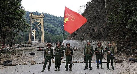 Members of the Myanmar National Democratic Alliance Army pose for a photograph with the group's flag in front of the Kunlong bridge in Kunlong township in Shan state. (Photo | AP)