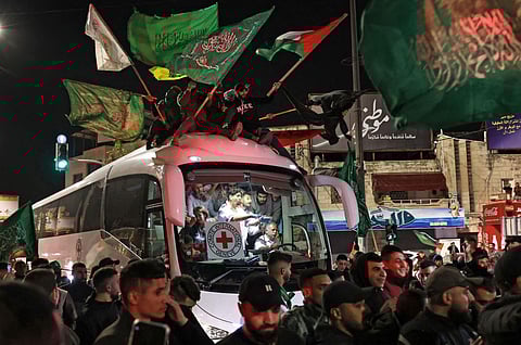 Crowd surrounds a Red Cross bus carrying Palestinian prisoners released from Israeli jails, in exchange for hostages released by Hamas from Gaza, in occupied West Bank, Nov 26, 2023. (Photo | AP)
