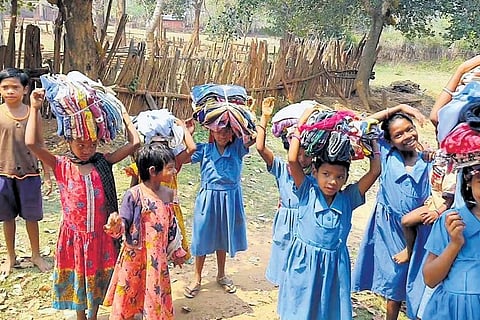 Tribal children of Puja Ghati in Kandhamal carry clothes provided by Paital | Express