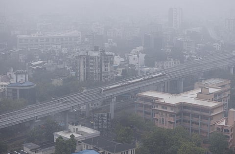 An aerial view of the Gujarat Metro train passing by amid hazy weather conditions after rain, in Ahmedabad, Sunday, Nov. 26, 2023.  (Photo | PTI)