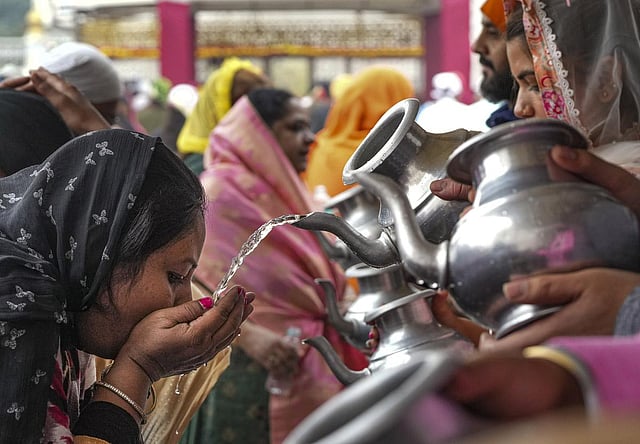 Volunteers distribute holy water or 'amrit' to devotees at the Gurdwara Bangla Sahib on Guru Nanak Jayanti, in New Delhi. (Photo | PTI)