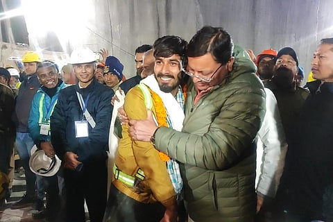 Uttarakhand Chief Minister Pushkar Singh Dhami greets a worker rescued from the site of an under-construction road tunnel that collapsed in Silkyara in Uttarakhand, on Nov 28, 2023. (DIPR)