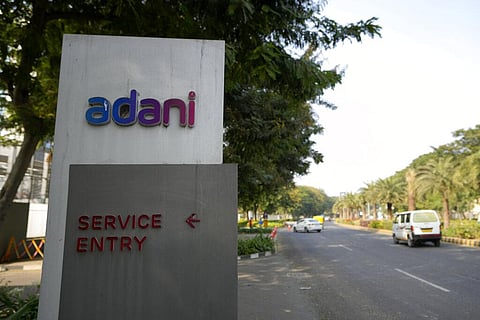 FILE - Vehicles move past a signage near the entrance of Adani Corporate House in Ahmedabad, India.  (Photo | AP)