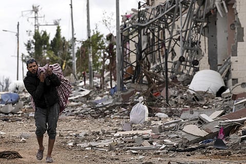 A Palestinian man collects his belongings souteast of the Gaza City on Tuesday, Nov 28, 2023. (Photo | AP)