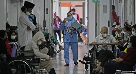 A nurse walks past patients in a hallway at Persahabatan Hospital, a national respiratory referral hospital, in Jakarta, Indonesia. (Photo | AP)