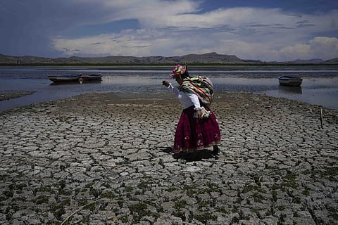 FILE - A woman walks on a dried out portion of Lake Titicaca in Coata, Peru, Wednesday, Nov. 29, 2023, due to falling water levels amid a winter heat wave. (AP Photo)