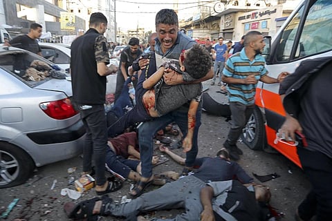 A man steps over the bodies of dead and injured Palestinians lying on the ground following an Israeli airstrike outside the entrance of the al-Shifa hospital in Gaza City, Nov 3, 2023. (Photo | AP)