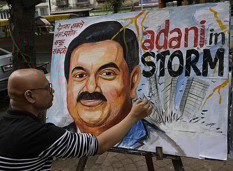 FILE - An artist gives final touches to a painting of Indian businessman Gautam Adani, depicting the ongoing crisis of the Adani group, in Mumbai. (Photo | AP)