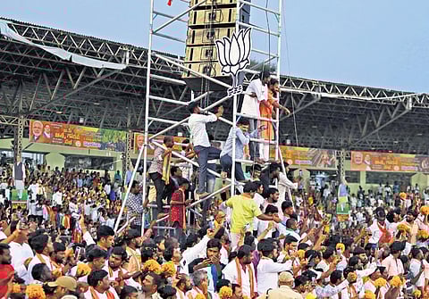 BJP supporters climb a post to catch a glimpse of Prime Minister Narendra Modi  at the LB Stadium in Hyderabad on Tuesday | Sri Loganathan Velmurugan