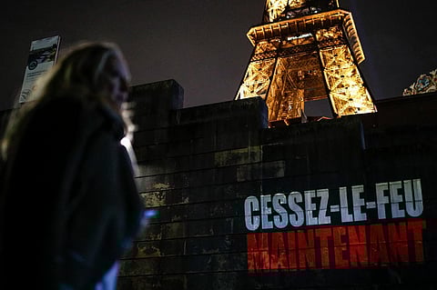 'Cessez-le-feu Maintenant' (Ceasefire Now) is projected on a wall along the Seine river bank at the foot of the Eiffel tower, as part of an initiative by Amnesty International, and others. (AFP)