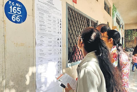 First-time voters go through the list of candidates before heading to cast their vote, at a polling booth in Charminar constituency on Thursday | renuka kalpana