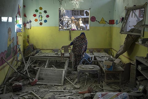 Palestinian woman cleans up after an Israeli strike on her neighborhood in Rafah, Gaza Strip. (Photo | AP)