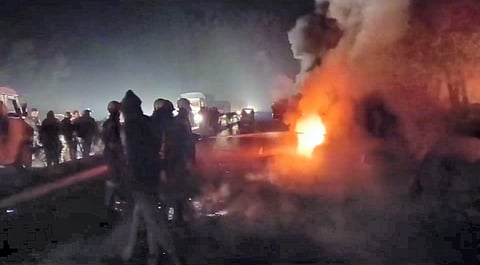 Firefighters and police personnel at the spot after an SUV caught fire following a collision with a truck on the Bareilly-Nainital road, in Bareilly district.