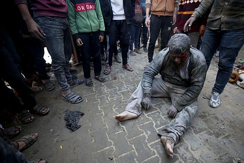 People gather around a survivor pulled from the rubble of a building following Israeli strikes on the al-Maghazi refugee camp in central Gaza, on December 11, 2023. (AFP Photo)