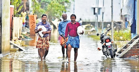 Residents of Sai Balaji Nagar wading through flood water carrying relief materials | P Ravikumar