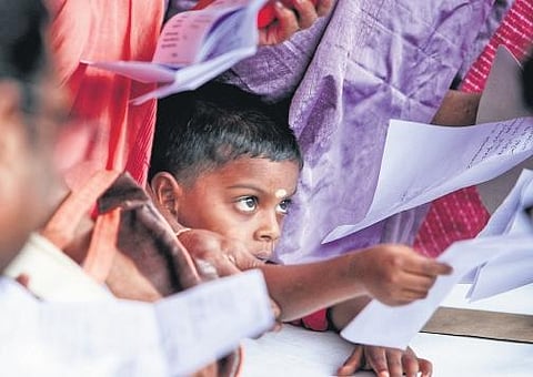 Four-year-old Adi Danish, a resident of Mariyapuram, hands over a letter requesting financial help from the government to complete the construction of his house, at the counter of Nava Kerala Sadas.